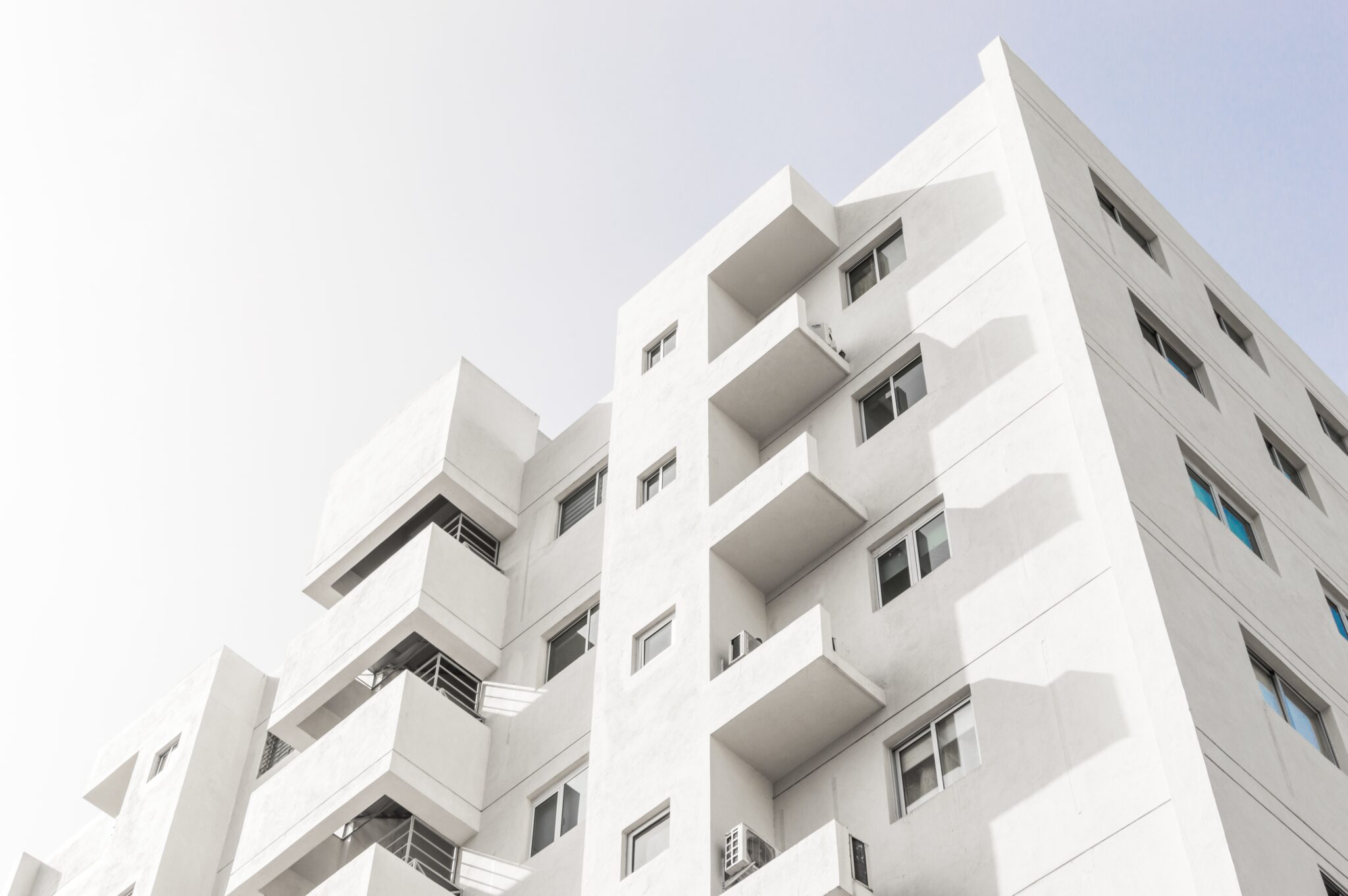 low angle shot facade white modern building blue clear sky